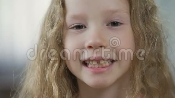 有趣的金发孩子在镜头里露出牙齿孩子们的牙齿矫正健康视频的预览图
