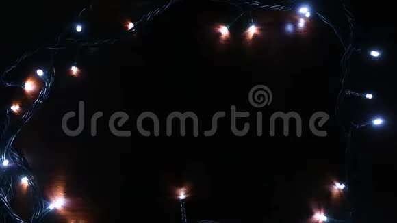 男人手纠正花环木制背景上的五颜六色的圣诞灯视频的预览图