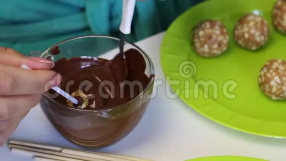 一个女人把饼坯浸入融化的巧克力中接下来的盘子是现成的空白视频的预览图