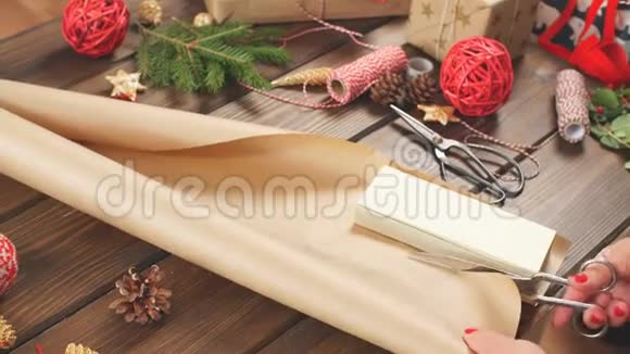 女人的手在黑暗的木制背景上包装圣诞礼物视频的预览图