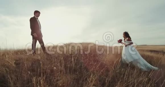 新郎站在风景中间新娘走到他身边互相抱着亲吻着视频的预览图