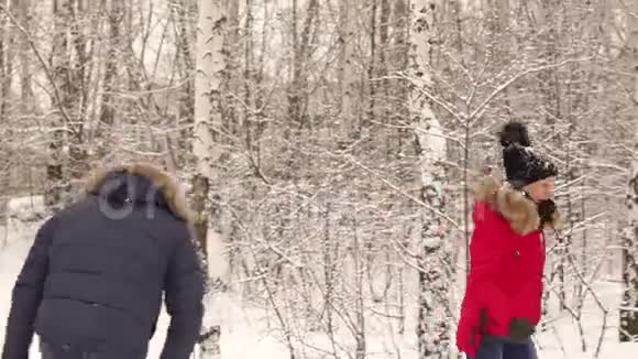 恋爱中的情侣在白雪覆盖的公园里玩视频的预览图