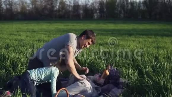 宽阔的草地绿草如茵年轻的父亲和两个女儿正在一起玩你个傻瓜最小的有视频的预览图