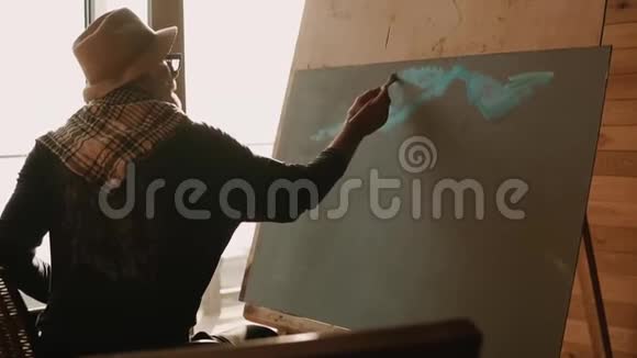 一位专业的绘画老师演示如何在画布上涂油漆视频的预览图