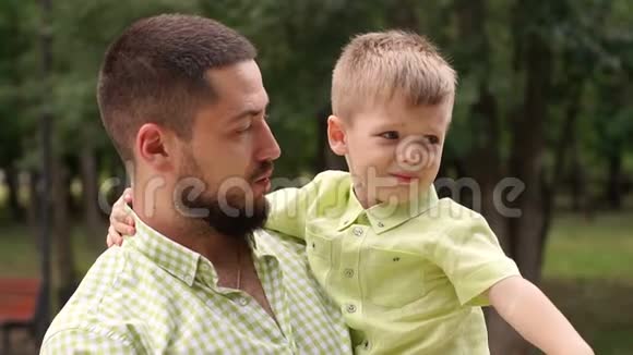 爸爸把哭着的儿子抱在公园里视频的预览图