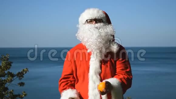 一个穿着圣诞老人服装的人在海边玩橘子旅行和度假视频的预览图