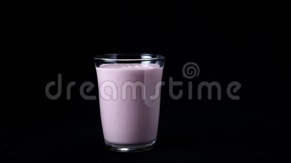 草莓奶昔分离在黑色背景上框架透明玻璃上面有粉红色的奶昔视频的预览图
