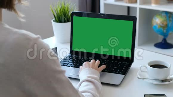 女人在电脑上工作绿色屏幕在肩膀上射击视频的预览图