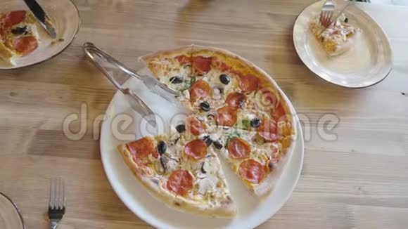 女人想在餐馆里吃一片热比萨饼一家人吃真正的意大利披萨玩得开心生活方式和视频的预览图