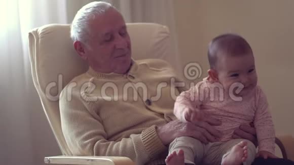 快乐爷爷手牵着宝宝在室内生孩子快乐概念慢动作视频的预览图