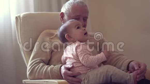 快乐爷爷手牵着宝宝在室内生孩子快乐概念慢动作视频的预览图