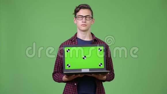 年轻英俊的青少年书呆子男孩展示笔记本电脑视频的预览图