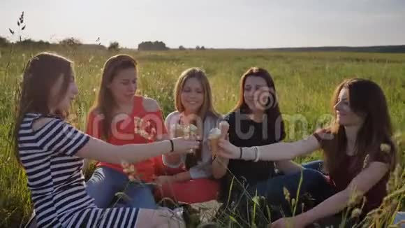 五个年轻的女学生正在草地上吃冰淇淋手里拿着冰淇淋视频的预览图