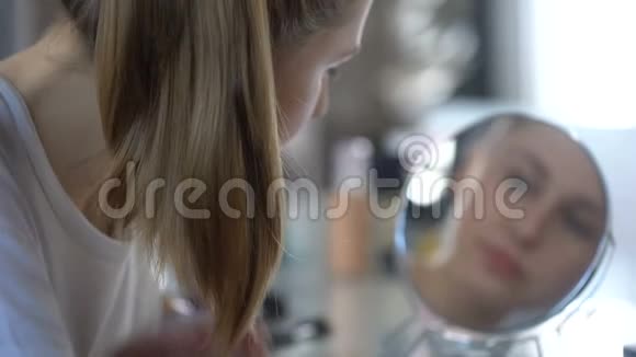 年轻女士梳着光滑的丝质头发享受倒影为造型准备香膏视频的预览图