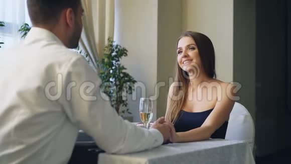 漂亮的年轻女人在餐馆里从男朋友那里得到求婚后感到高兴和惊讶她是视频的预览图
