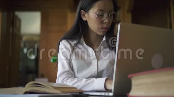 漂亮的亚洲女学生生物学家眼镜阅读书视频的预览图