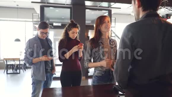 早上排队的年轻人站在咖啡屋里用手机买外卖饮料现代视频的预览图