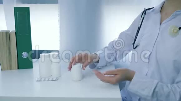 营养补充剂医生营养师双手打开维生素罐将黄色的圆形药丸倒入掌心涂在白色上视频的预览图