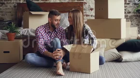 已婚夫妇在新房子里坐在地板上正在整理私人物品年轻人有说有笑视频的预览图