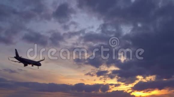 客机飞过头顶背景中的日落超高清的库存视频的预览图