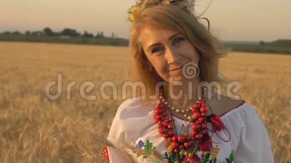 慢动作特写美丽的女人在国家服装与麦穗在手在麦田视频的预览图