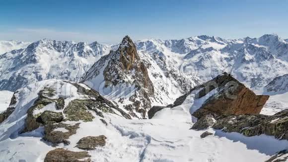 美丽的阳光明媚的冬季在雪山阿尔卑斯山时间流逝多利在雪岩和雄伟的山峰上拍摄视频的预览图
