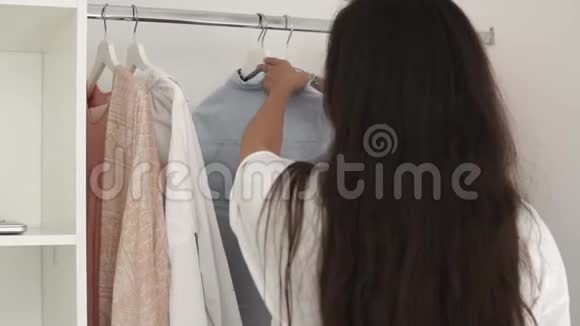 女孩正在房间里看衣服决定早上穿什么视频的预览图