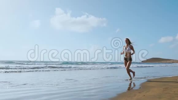 跑步妇女女跑步者在海滩户外锻炼时慢跑户外健身模特视频的预览图