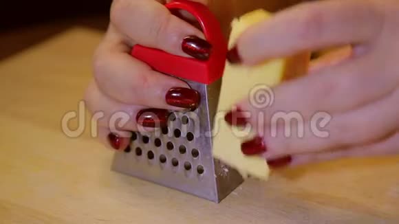 一个女人在粗磨砂上摩擦奶酪做沙拉视频的预览图