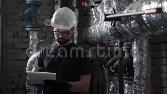 锅炉房的现代工程师在平板电脑上做笔记以作论文视频的预览图