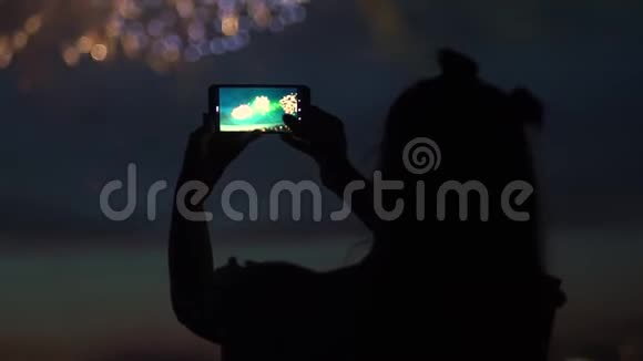 一个女孩在智能手机上燃放烟花慢动作视频的预览图