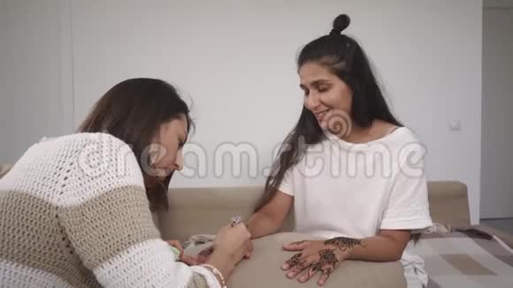 两个朋友正在画手上的指甲花以获得一个强有力的护身符视频的预览图