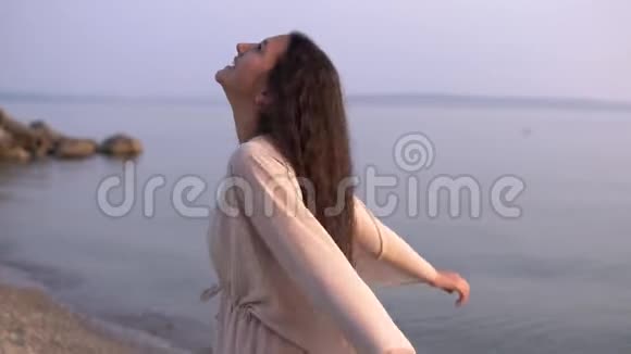 一个穿着沙滩长袍的漂亮女孩转过身来微笑着心情很好慢动作高清高清视频的预览图