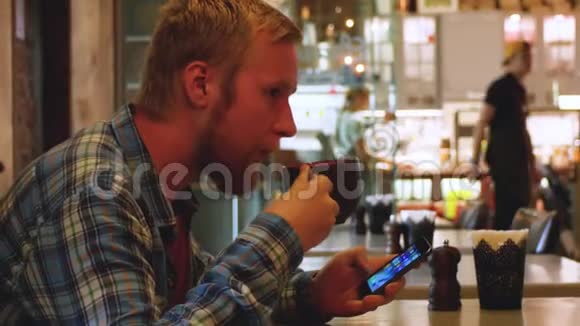 年轻人在咖啡馆里喝茶手里拿着电话学生午餐在咖啡馆商人解决问题视频的预览图