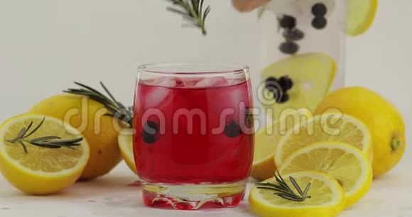 在杯中加入迷迭香支配苏打柠檬水红鸡尾酒视频的预览图