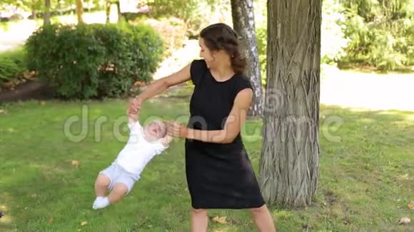 夏天一位年轻快乐的母亲在公园里和她刚出生的儿子玩耍视频的预览图