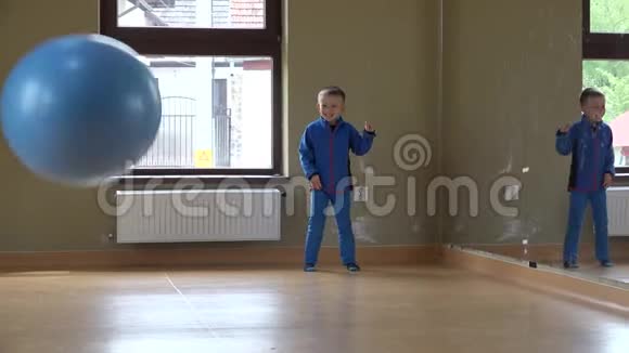 快乐的小孩在健身房玩大球很多球不打灵活的男孩视频的预览图