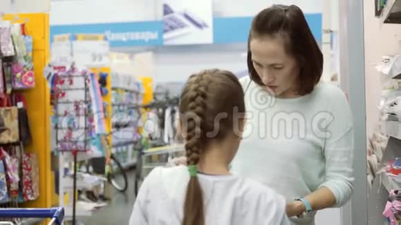 一个有一个小女儿的女人正在为学校买练习本购买学习用品视频的预览图