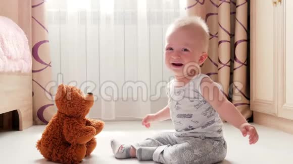 小男孩抱着玩具熊坐在地板上哭视频的预览图