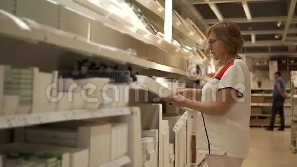 一位老年妇女正在探索大型商店厨房的各种配件视频的预览图