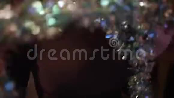 在圣诞晚会上穿着Tinsel和漂亮裙子的女人玩得开心跳舞视频的预览图