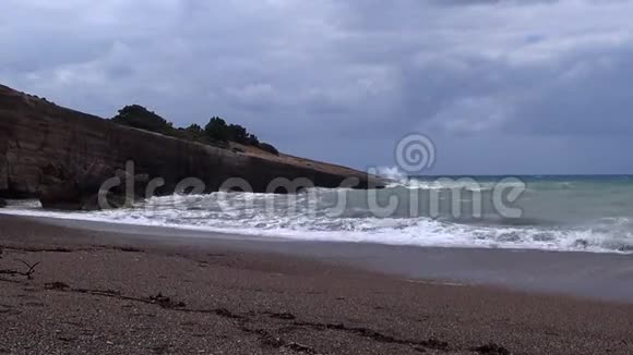 乌云密布的天空海浪拍打着海岸上的岩石视频的预览图
