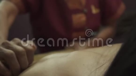 年轻女子躺在水疗床上用竹棍按摩视频的预览图