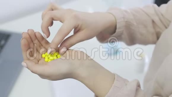 年轻女子手里拿着许多黄色的小药丸吃了一粒视频的预览图