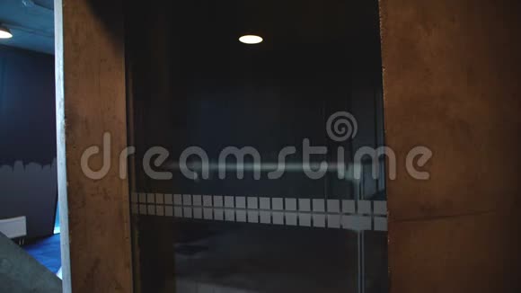 一个年轻放松的欧洲男人坐在透明的玻璃墙电梯里在电话里交谈微笑着视频的预览图