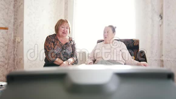 老年妇女坐下来休息看电视视频的预览图
