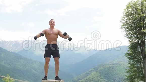 肌肉发达的男性运动员举起手臂做举重练习哑铃视频的预览图