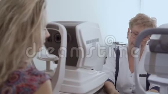 医生在检查了年轻女子的视力后与她交谈视频的预览图