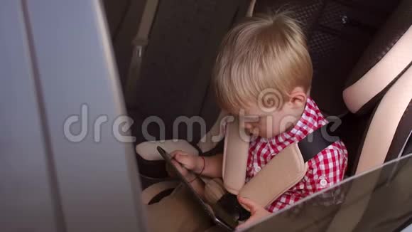 一个小孩子的肖像车后座上有一个平板电脑视频的预览图