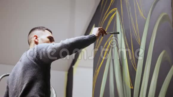 涂鸦艺术家在墙上画油漆男性用刷子视频的预览图